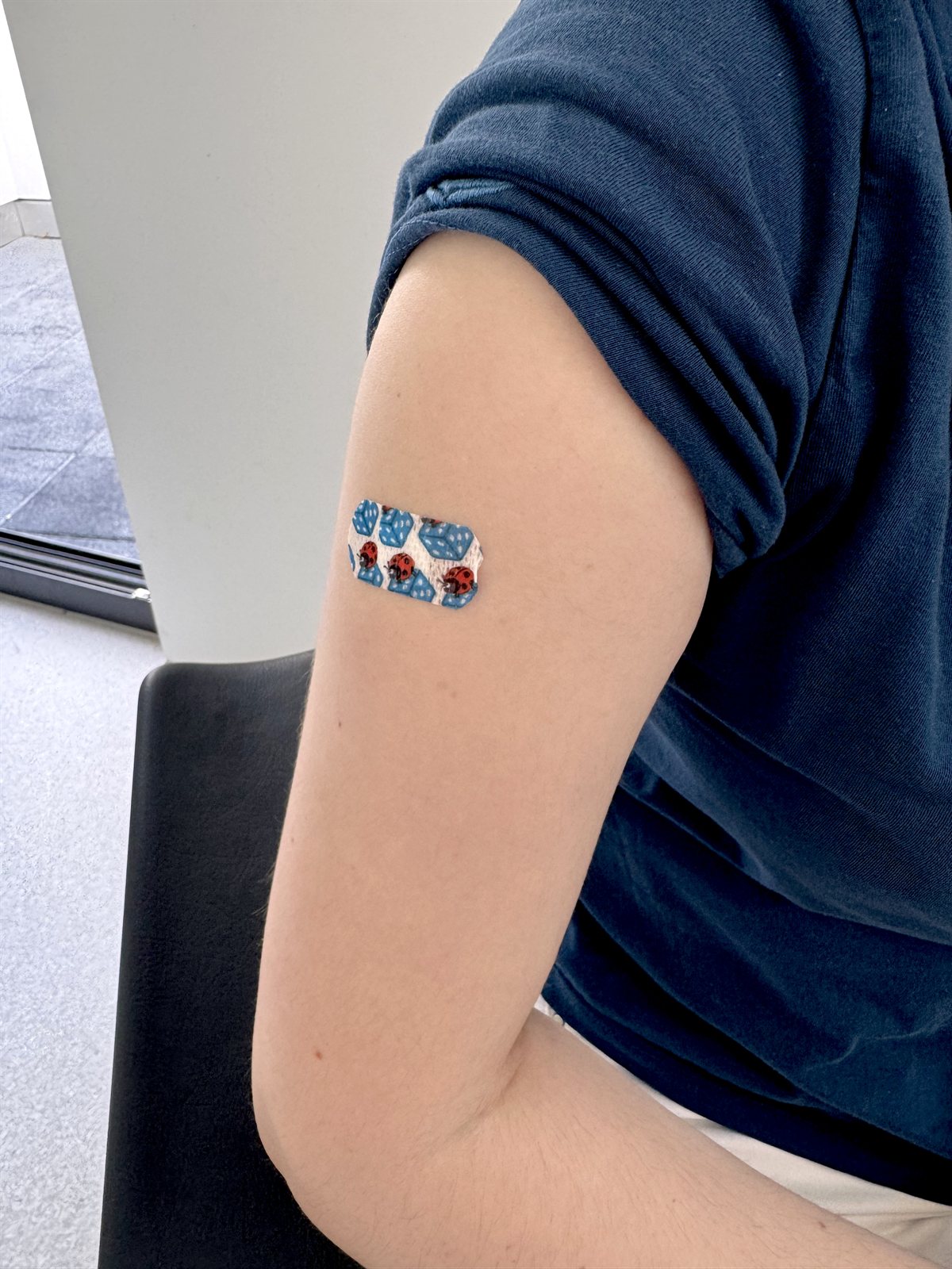 Arm mit buntem Pflaster nach einer Impfung